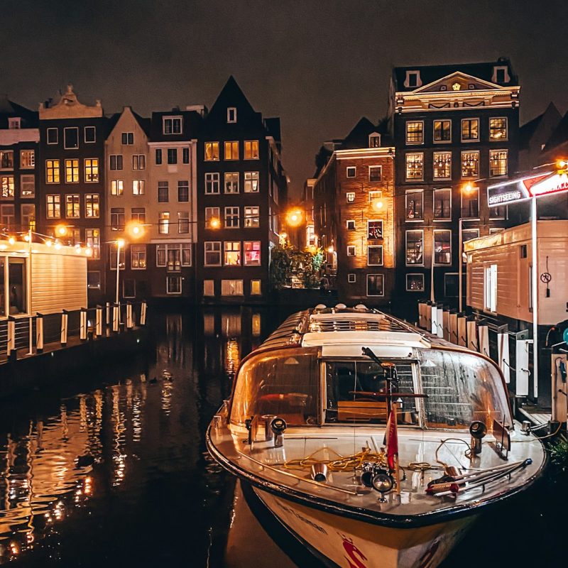 Amsterdam canals by night. Night life in Amsterdam on. Lights reflected in the canals water.